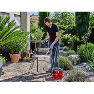 Mann reinigt Grill mit Einhell Aschesauger TC-AV 1718 D (1200 W).