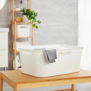 Weißer Rotho Wäschekorb Brisen (41 l) mit Wäsche auf einem Holztisch im Badezimmer.