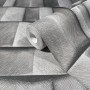 Graue Marburg Vliestapete mit grafischer 3D-Optik, Rolle teilweise aufgerollt.