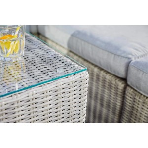 Detailaufnahme: Lounge-Sessel Olea aus Polyrattan in Sand mit Glasplatte und Getränk. Gartenmöbel für entspannte Stunden.