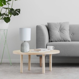 Näve Tischleuchte Folio Keramik Weiß auf Tisch, Wohnzimmeratmosphäre.