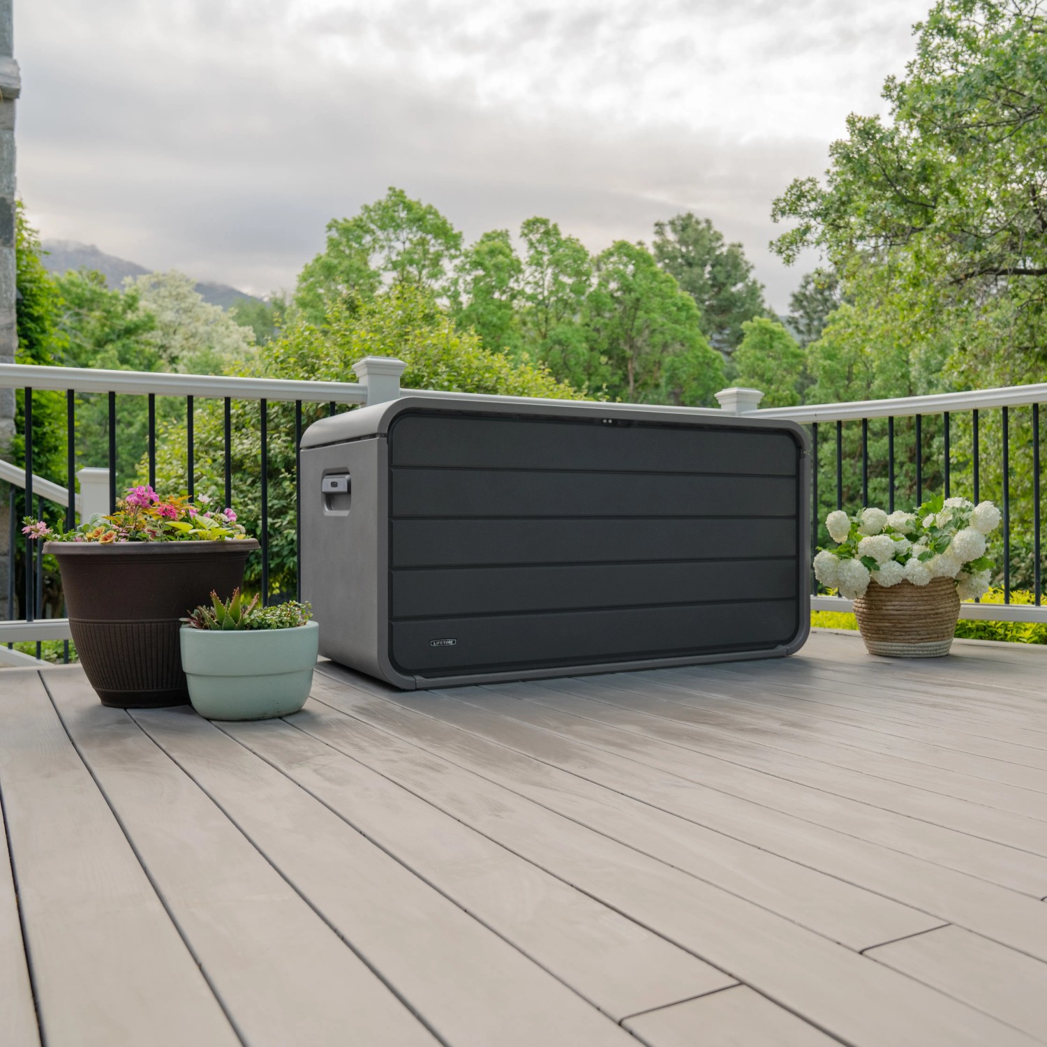Graue Lifetime Kissenbox 625 l auf Terrasse, ideal zur Aufbewahrung von Gartenutensilien.