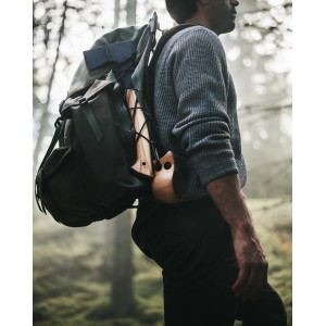 Person mit Rucksack und Fiskars Axt Norden N7. Universalaxt mit Holzgriff für Outdoor-Aktivitäten.