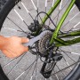 Fahrrad-Pflegeset: Detailaufnahme einer Ritzelreinigung mit Werkzeug am Hinterrad eines Fahrrads.