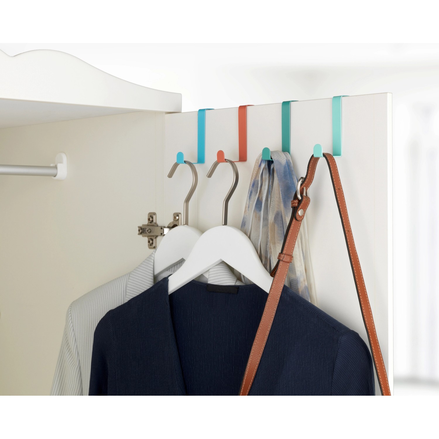 Wenko Türgarderobenhaken 4er-Set, farbig sortiert, an Tür mit Kleidung.