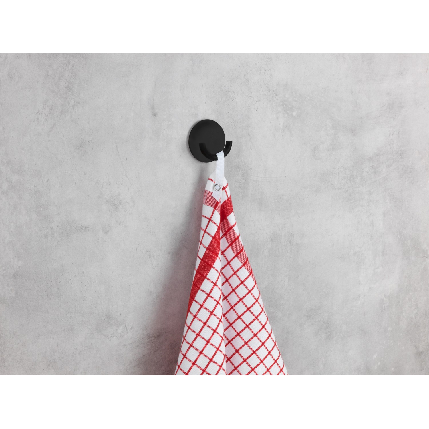 Schwarzer Wenko Küchenhaken Rondo aus Edelstahl mit Geschirrtuch an grauer Wand.