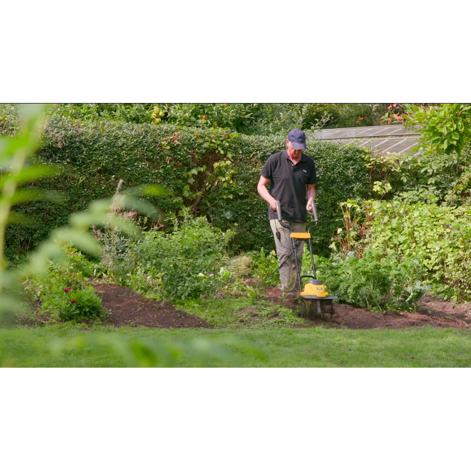 Mann benutzt Texas Elektro-Motorhacke El-Tex 1000 im Garten.