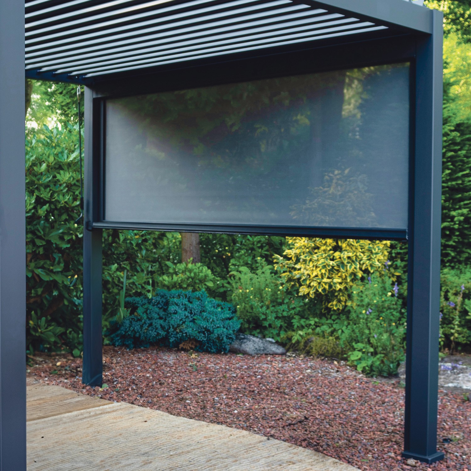 Anthrazitfarbenes Sonnenrollo Mirador 3 m an einer Terrassenüberdachung.