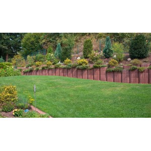 Beispielhafte Gartengestaltung mit braunen Premac Parkflor Pflanzringen als Hangbefestigung.