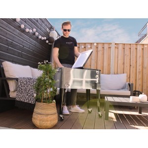 Axi Kühlwagen Retro Edelstahl 76 l mit Mann im Garten, ideal für Partys und BBQs.