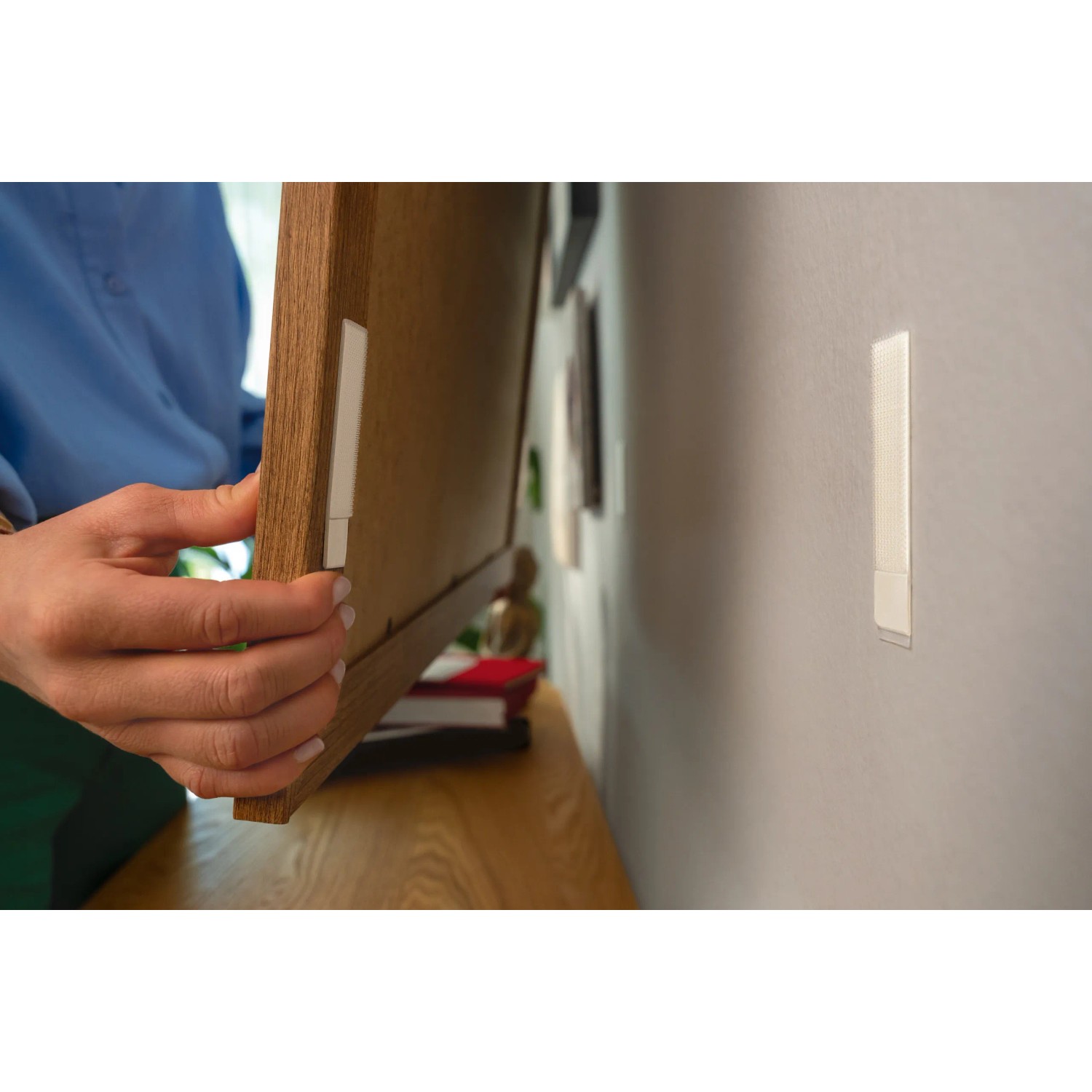 Anwendung der Tesa Powerstrips Click Small: Bilderrahmen wird an der Wand befestigt.