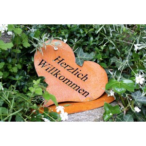 Rostbraunes Herz aus Metall mit "Herzlich Willkommen" Schriftzug als Gartendeko.