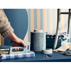 Rapid Handtacker R53 Skärgård beim Tackern von blau kariertem Stoff.