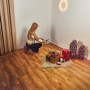 Frau baut künstlichen Weihnachtsbaum Nagano 180cm mit LED-Beleuchtung auf. Deko-Elemente im Raum.