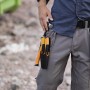 Fiskars Handwerkermesser mit Holster und Messerschärfer am Gürtel eines Handwerkers.