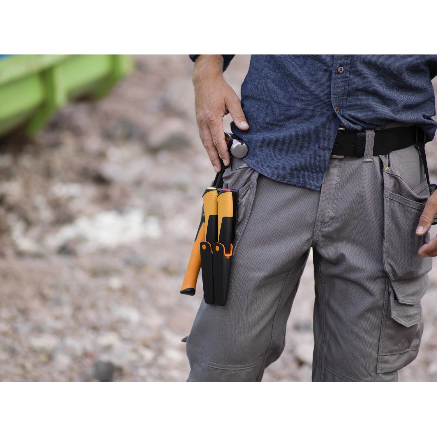 Fiskars Handwerkermesser mit Holster und Messerschärfer am Gürtel eines Handwerkers.