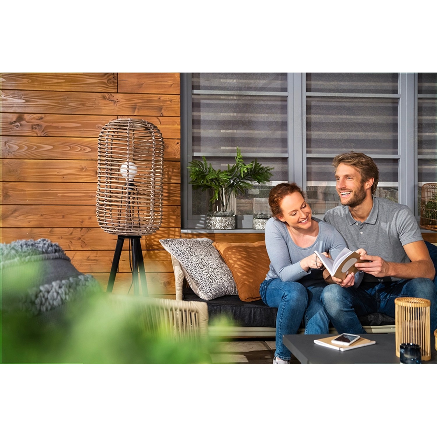 Holzterrasse mit Paar und Xyladecor Holzschutz-Lasur im Hintergrund. Holzlasur schützt das Holz.