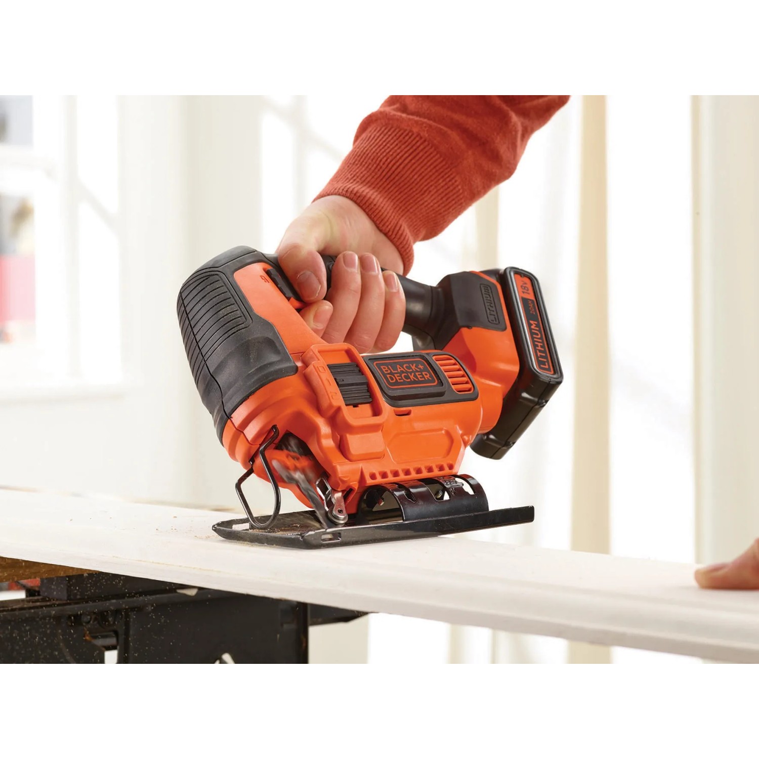 Black+Decker Akku-Stichsäge BDCJS18 beim Sägen von Holz. Kompakte, orange-schwarze Stichsäge.