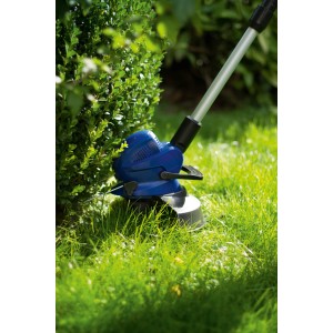 LUX Fadenkassette T 397 für Rasentrimmer im Einsatz, schneidet Gras an einem Busch.