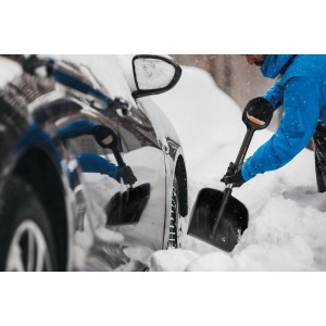 Fiskars Autoschaufel Telescopic X-series beim Freischaufeln eines Autos im Schnee.