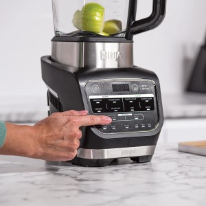 Ninja Foodi Mixer & Suppenkocher HB150EU in Aktion: Eine Hand bedient das Bedienfeld.