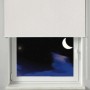 Gardinia Verdunkelungsrollo Thermo, weiß, mit Streifenmuster vor einem Fenster in der Nacht.