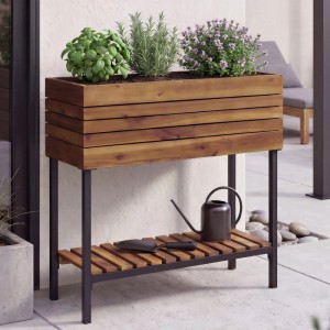 Braunes MCW Hochbeet aus Akazienholz mit schwarzem Metallgestell, Ablage und Kräutern für Balkon/Garten.