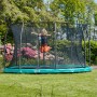 Grünes Salta Comfort Edition Bodentrampolin ø 396 cm mit Kind im Garten.