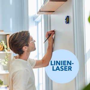 Mann markiert Wand mit Dremel Akku-Bohrschrauber DD12V-S1 und Linienlaser für präzises Bohren.