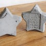 Zwei graue Sterne aus Ultrament Knet Beton, einer mit Aufhängeschnur, einer mit Schriftzug.