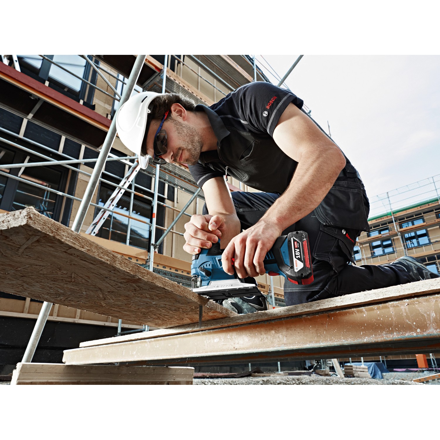 Bosch Akku-Stichsäge GST 12V-70 in Nutzung: Handwerker sägt Holz mit der Stichsäge auf einer Baustelle.