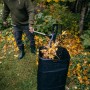 Mann befüllt Laubsack mit Fiskars Ergonomic Schaufelrechen. Besen & Rechen für Gartenarbeit.