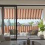 Spettmann Fallarmmarkise Line, weiß/gelb-orange-rot gestreift, auf einem Balkon montiert.