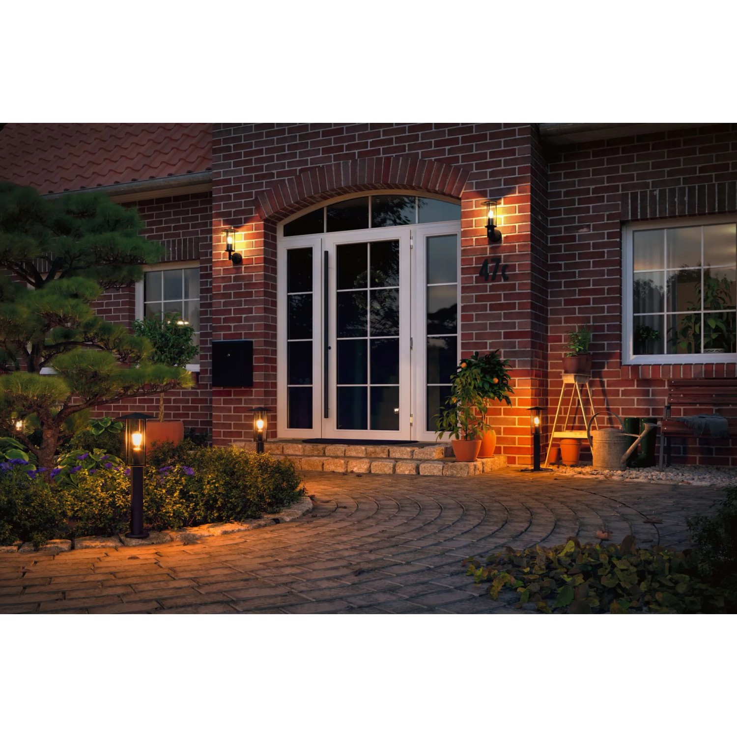 Paulmann Classic Pollerleuchte in Schwarz vor einem Haus mit warmem Licht.