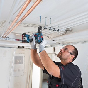 Handwerker bohrt mit dem Bosch Professional Akku-Schlagbohrschrauber GSB 18 V-28 in eine Decke.