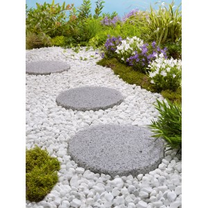 Naturstein-Trittsteine Sino Grau, Ø 25 cm, im Gartenweg mit weißen Zierkieseln.