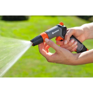 Gardena Reinigungsspritze Classic in Aktion: Graue Gartenspritze mit Wasserstrahl in der Hand.