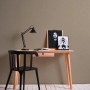 Beige-braune Vliestapete mit leichter Struktur an einer Wand hinter einem Schreibtisch.