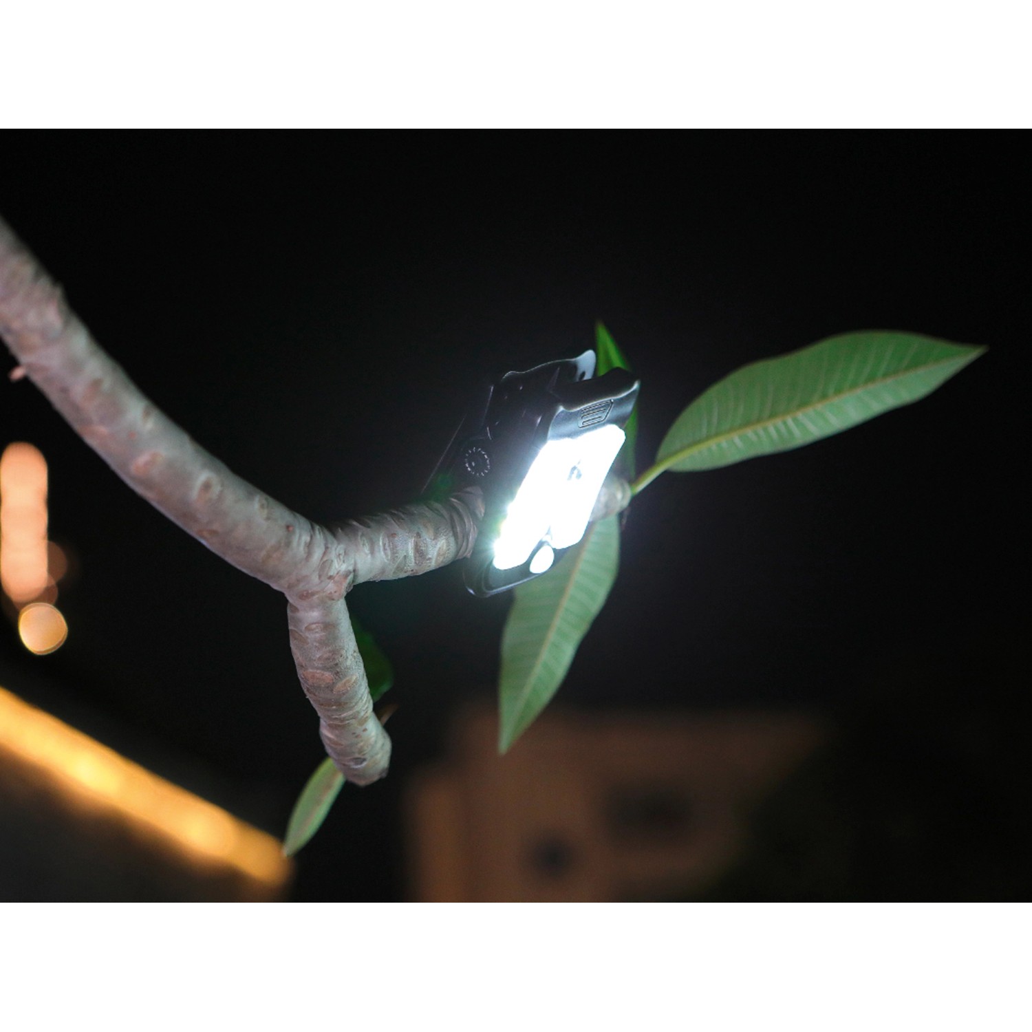 Schwarze Solar LED Gartenleuchte mit Clip an einem Ast, leuchtend.