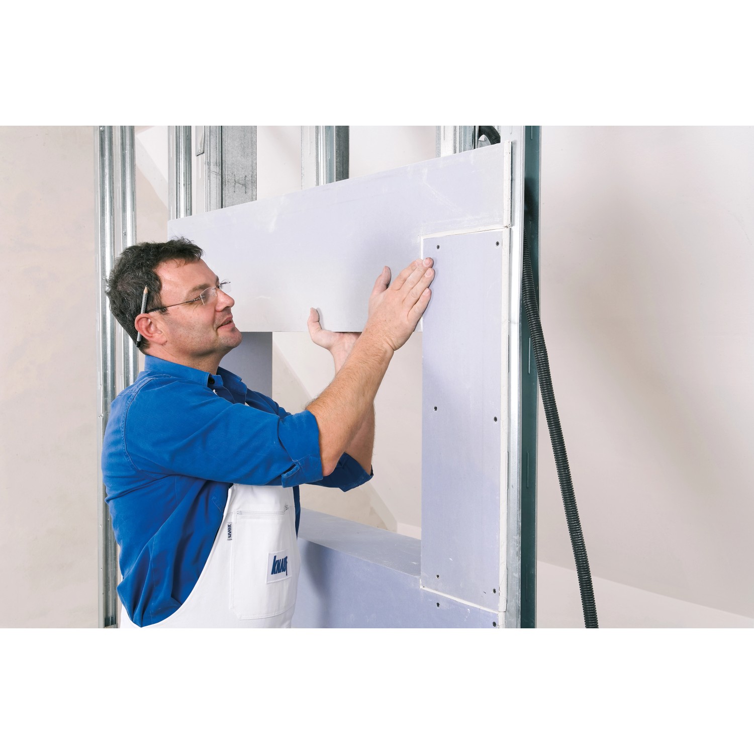 Handwerker montiert Knauf Ausbauplatte Diamant (Gipskartonplatte) an einer Wand.