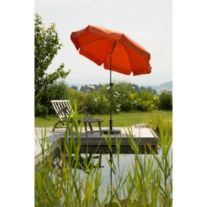 Terracottafarbener Schneider Balkonschirm Aquila Ø 200 cm mit Knickfunktion neben einem Gartenteich.