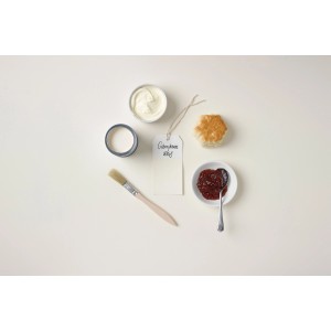 Rust-Oleum Kreidefarbe in Gebrochenes Weiß mit Pinsel, Marmelade und Brötchen auf hellem Grund.