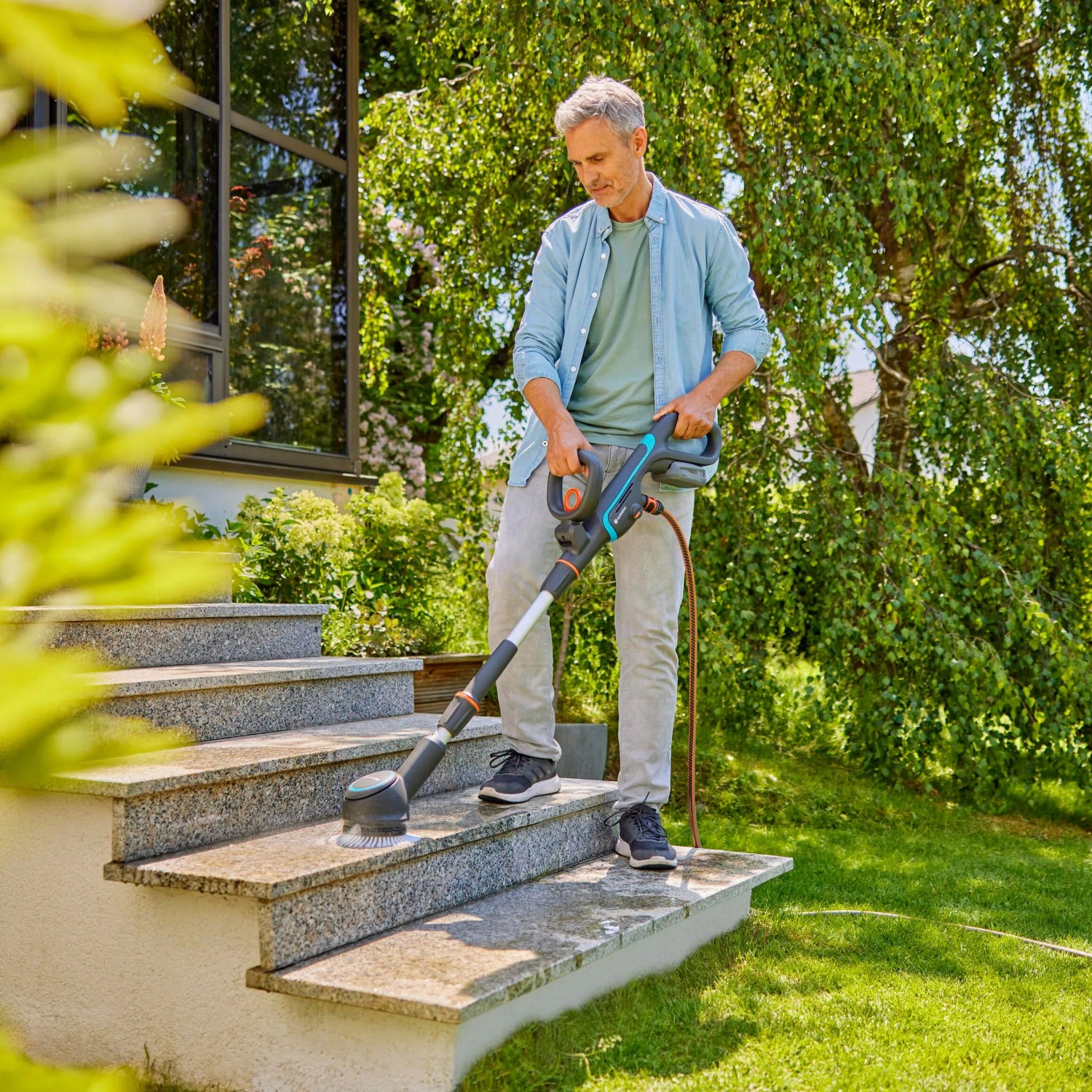 Gardena Akku-Multi-Reiniger AquaBrush im Einsatz zur Treppenreinigung im Garten.