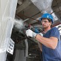Mann bohrt mit Bosch Professional Bohrhammer GBH 2-28 F in Wand. Inkl. Tiefenanschlag und L-Boxx.