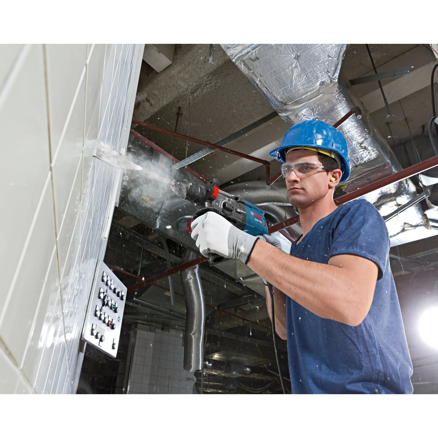 Mann bohrt mit Bosch Professional Bohrhammer GBH 2-28 F in Wand. Inkl. Tiefenanschlag und L-Boxx.