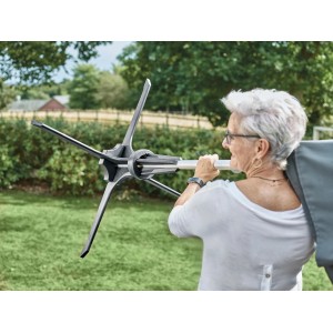 Frau trägt Baser Sonnenschirmständer (50 kg, dunkelbraun). Stabiler Schirmhalter für Garten & Terrasse.