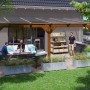 Skan Holz Terrassenüberdachung Bormio, 648x250 cm, Leimholz Nussbaum mit klarer Dacheindeckung.