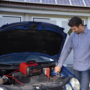 Einhell CE-BC 15 M Batterieladegerät im Einsatz unter der Motorhaube eines Autos.