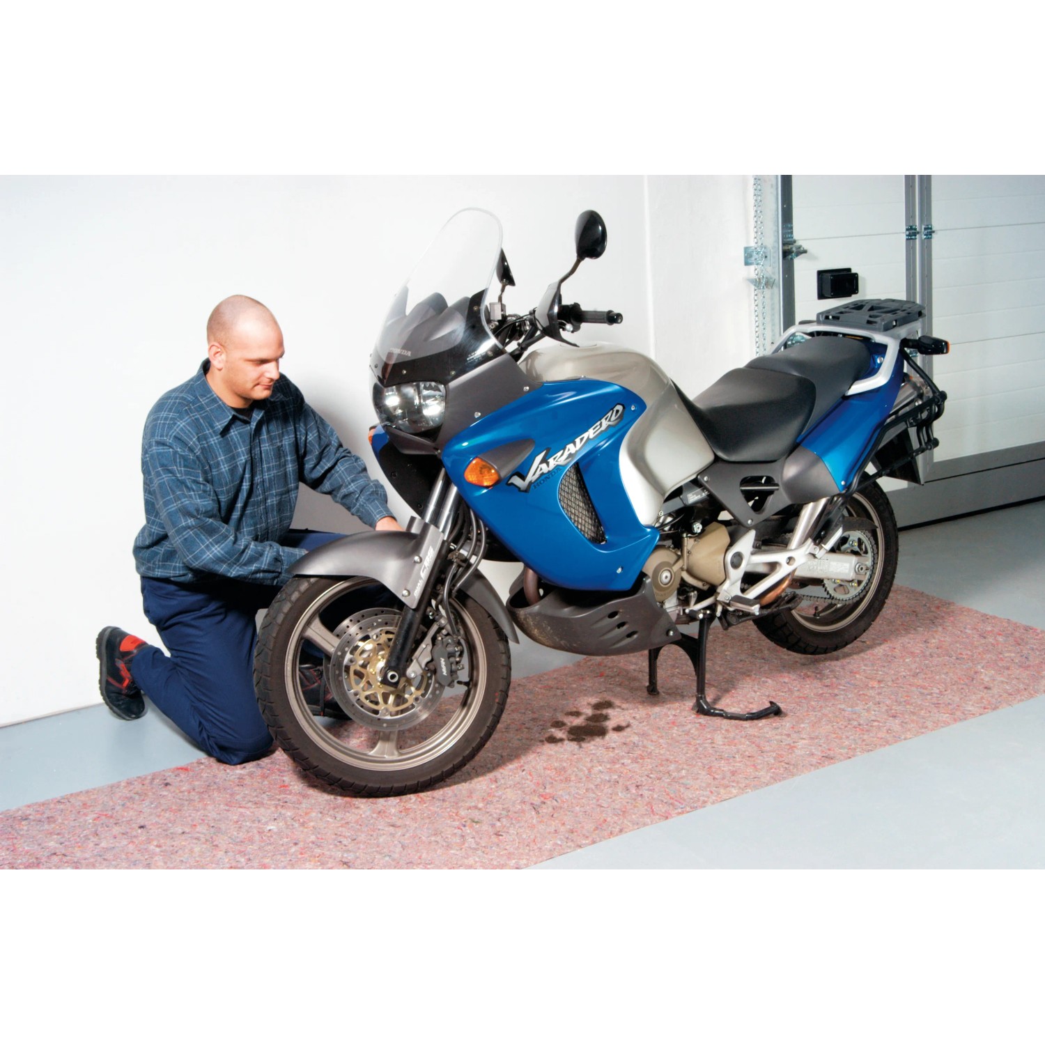 Motorrad auf LUX Abdeckvlies 1x3m. Das Vlies schützt den Boden vor Öl und Schmutz.