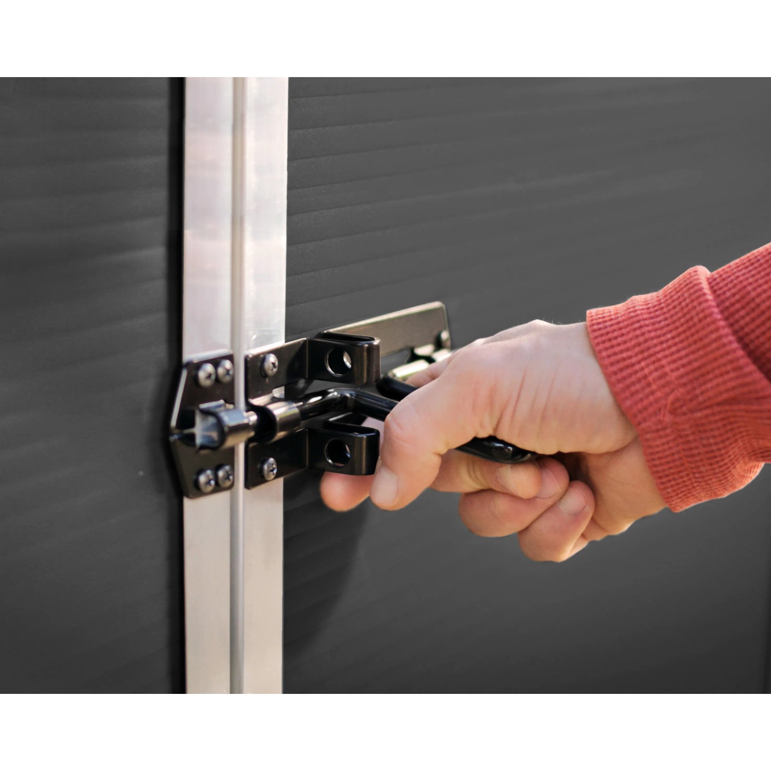 Detailaufnahme: Hand schließt Riegel am grauen Palram Canopia Gerätehaus Rubicon.